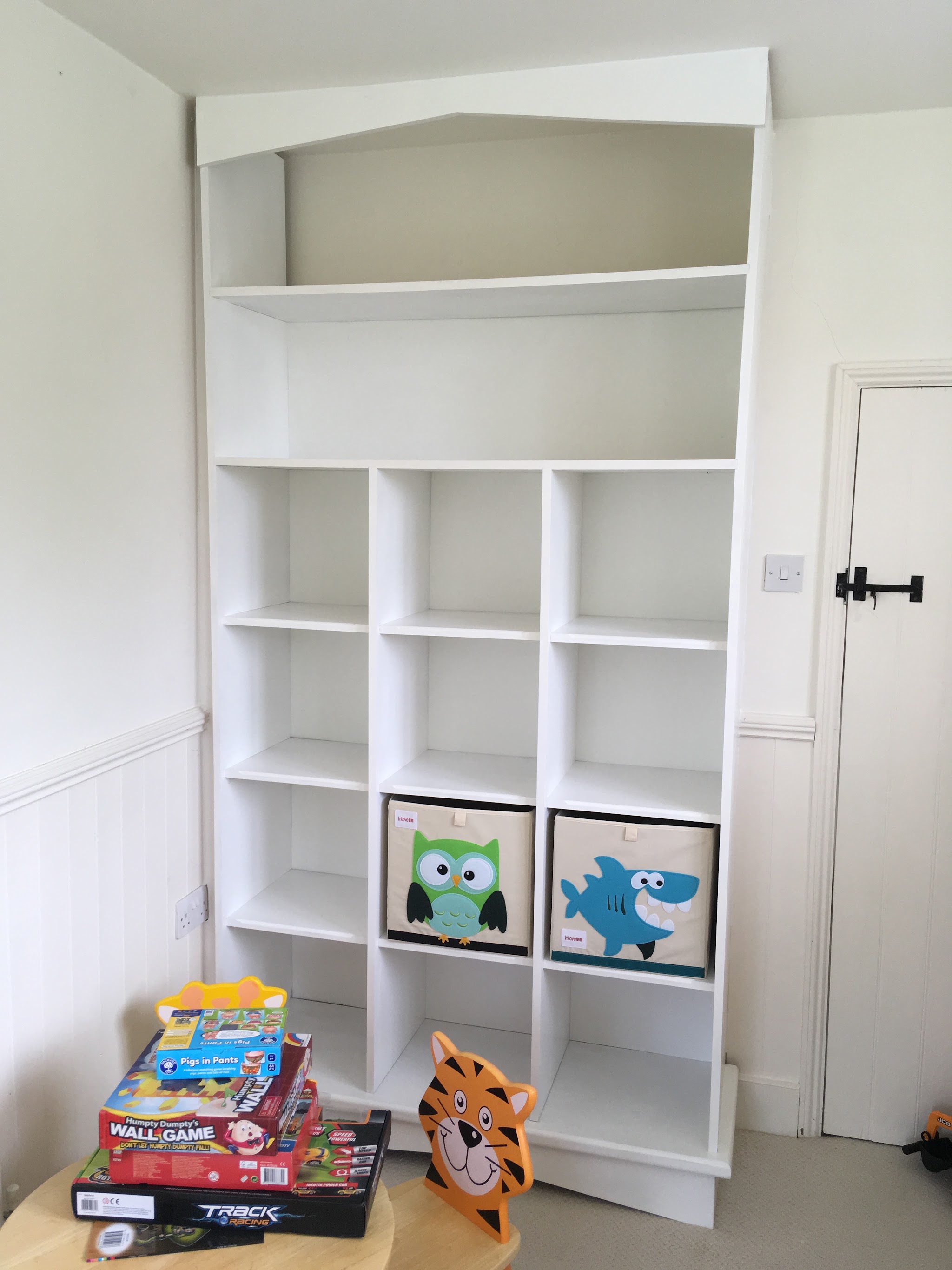 A bespoke white shelving unit with cube storage built into an alcove
