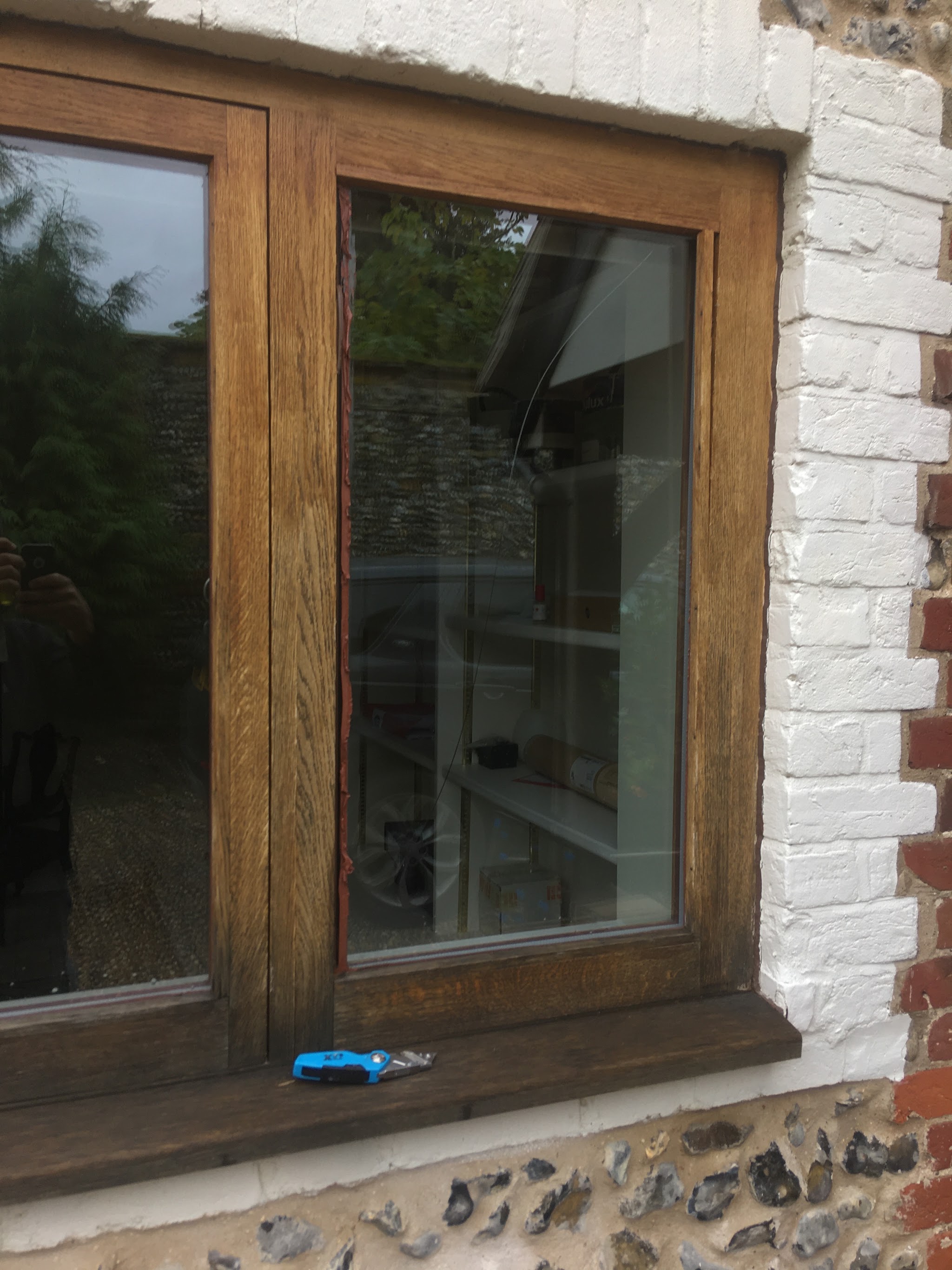 Oak casement window in a brick and flint wall